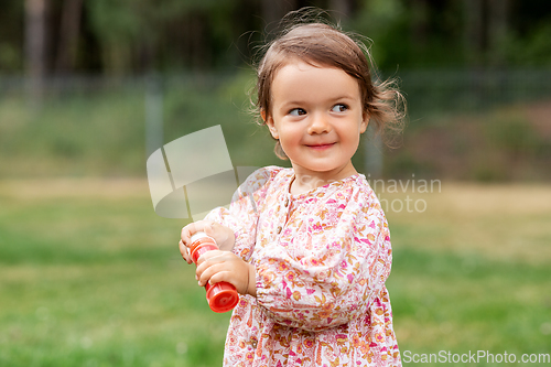 Image of happy baby girl with soap bubble blower in summer