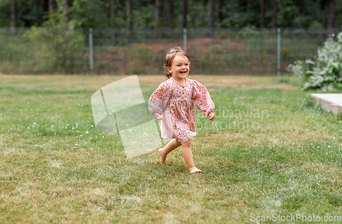 Image of happy little baby girl running barefoot on grass