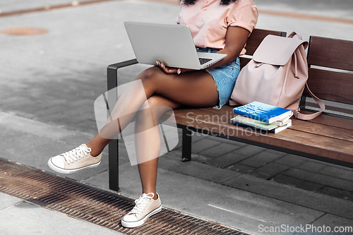 Image of african student girl with laptop and books in city