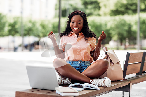 Image of african student girl with laptop and books in city