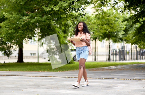 Image of african student girl with takeaway pizza in city