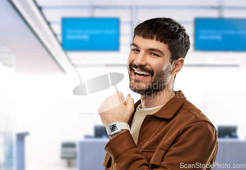 Image of man showing smart watch with qr code on screen