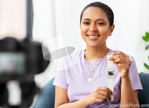 Image of female blogger showing smart watch with qr code