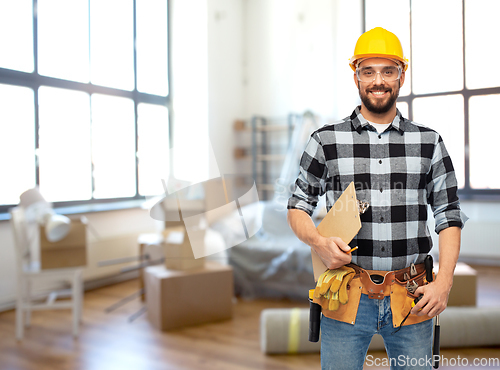 Image of male builder in helmet with clipboard at home