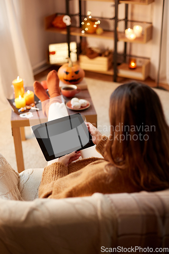 Image of woman with tablet pc at home on halloween