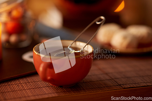 Image of mesh tea infuser ball in ceramic mug on halloween