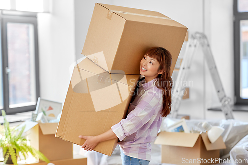 Image of happy woman holding boxes and moving to new home