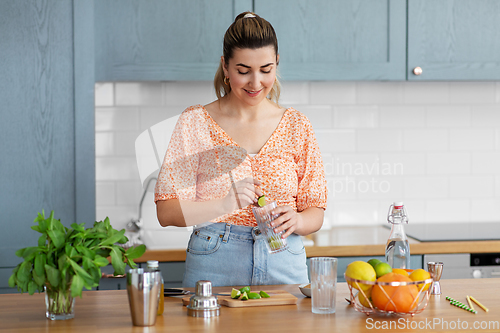 Image of woman making cocktail drinks at home kitchen