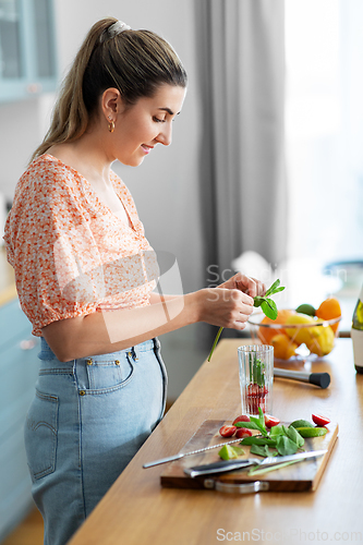 Image of woman making cocktail drinks at home kitchen