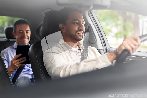 Image of indian male driver driving car with passenger