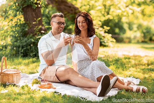 Image of happy couple having picnic at summer park