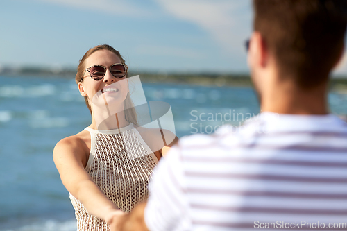 Image of happy couple hugging on summer beach