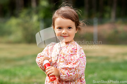 Image of happy baby girl with soap bubble blower in summer