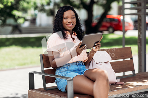 Image of african american woman with tablet pc in city