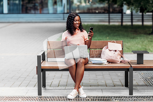 Image of african student girl with laptop and smartphone