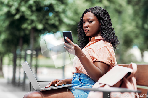Image of african student girl with laptop and smartphone