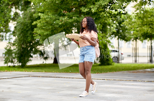 Image of african student girl with takeaway pizza in city
