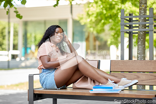 Image of african student girl with bag and books in city