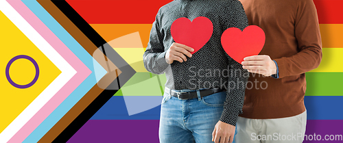 Image of close up of male gay couple with red hearts