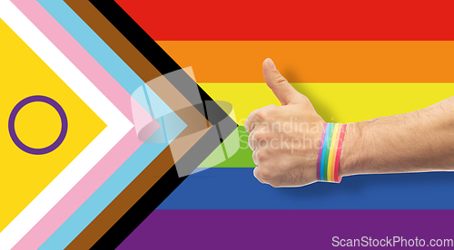 Image of hand with gay pride rainbow wristband shows thumb