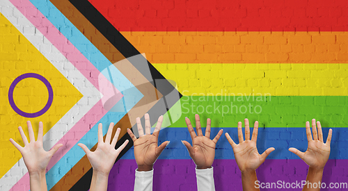 Image of multiracial hands over progress pride flag