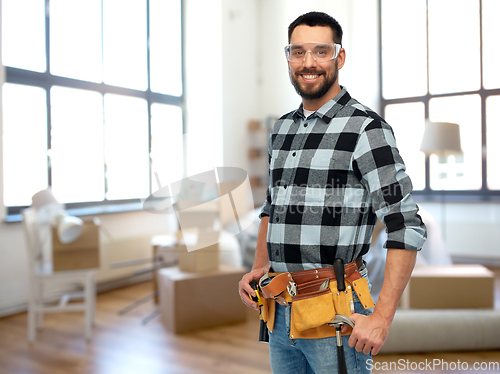 Image of happy male builder with tool belt at home