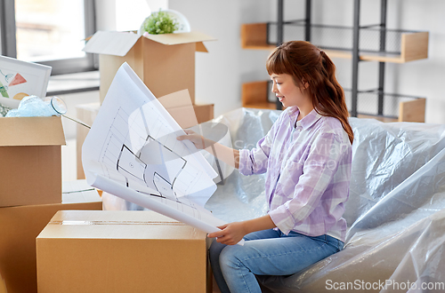 Image of woman with blueprint and boxes moving to new home