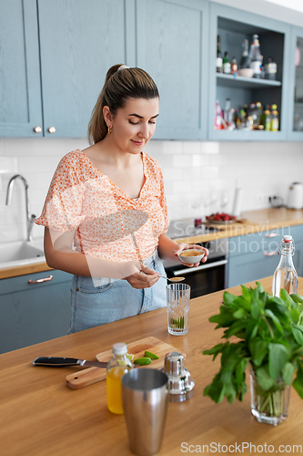 Image of woman making cocktail drinks at home kitchen