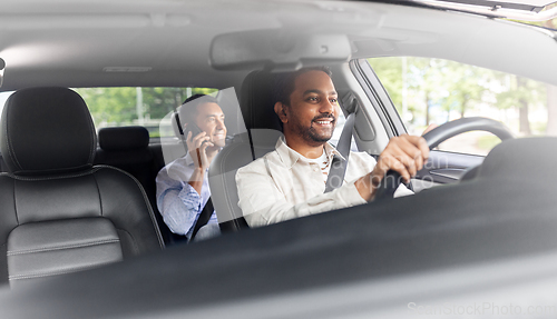 Image of male passenger calling on smartphone in taxi car