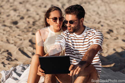 Image of happy couple with tablet pc at on summer beach