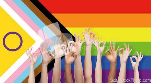 Image of hands showing ok sign over progress pride flag