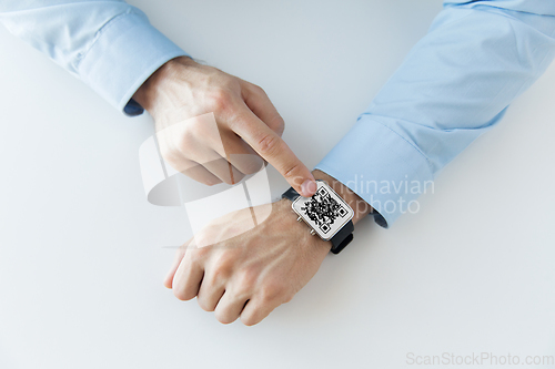 Image of man's hands with qr code on smart watch