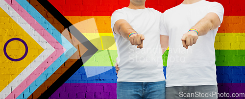 Image of close up of male gay couple over pride flag