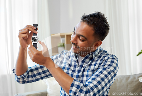 Image of man showing smart watch with qr code on screen