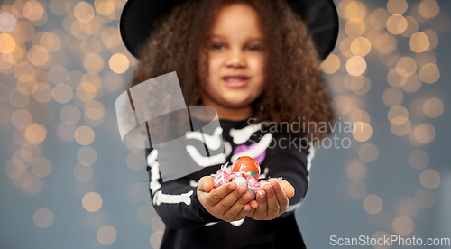 Image of girl with candies trick-or-treating on halloween