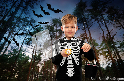 Image of boy with candies and flashlight on halloween