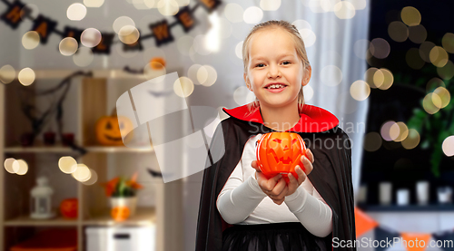 Image of girl in halloween costume of dracula with pumpkin