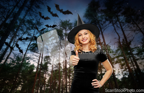 Image of happy woman in black halloween costume of witch