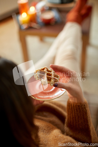 Image of close up of woman eating waffle at home
