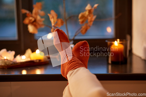 Image of feet in socks on window sill at home in autumn