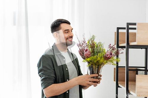 Image of man decorating home with flower or houseplant