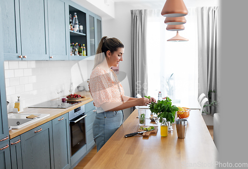 Image of woman making cocktail drinks at home kitchen