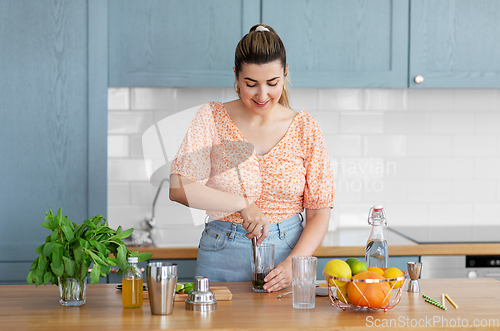 Image of woman making cocktail drinks at home kitchen