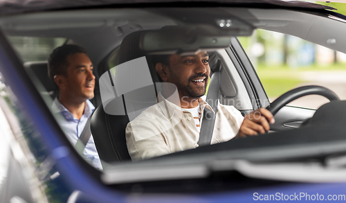 Image of indian male driver driving car with passenger