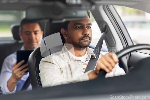 Image of indian male driver driving car with passenger
