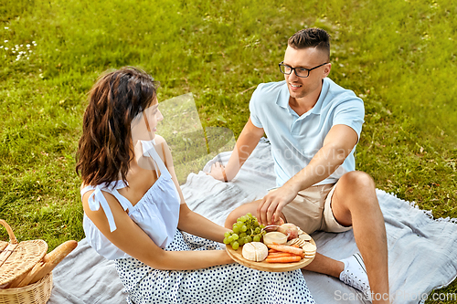 Image of happy couple having picnic at summer park