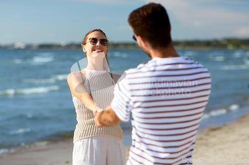 Image of happy couple hugging on summer beach