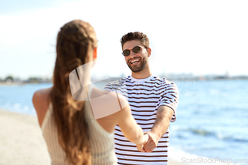 Image of happy couple hugging on summer beach