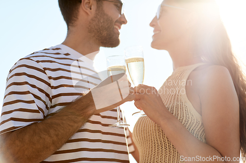 Image of happy couple drinking champagne on summer beach