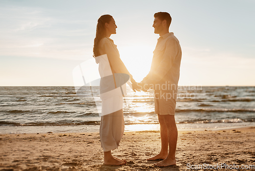 Image of happy couple holding hands on summer beach